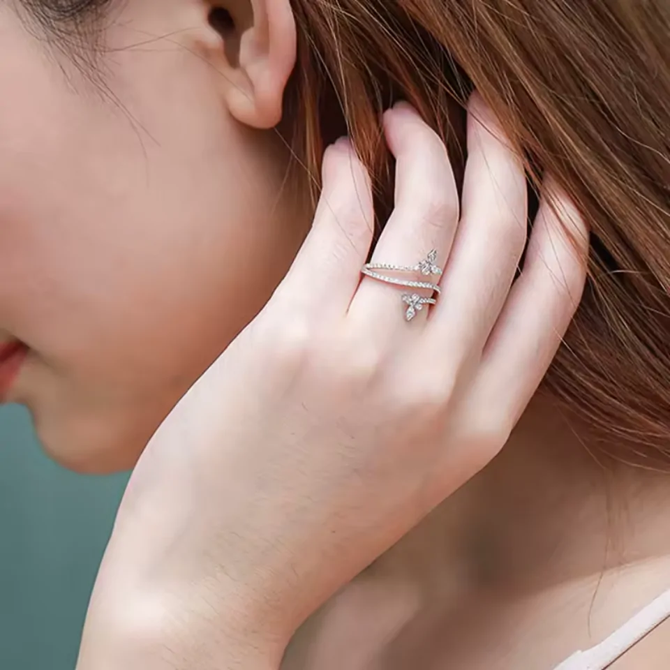 Bague papillon croisée portée au majeur, bandes pavées entrecroisées
