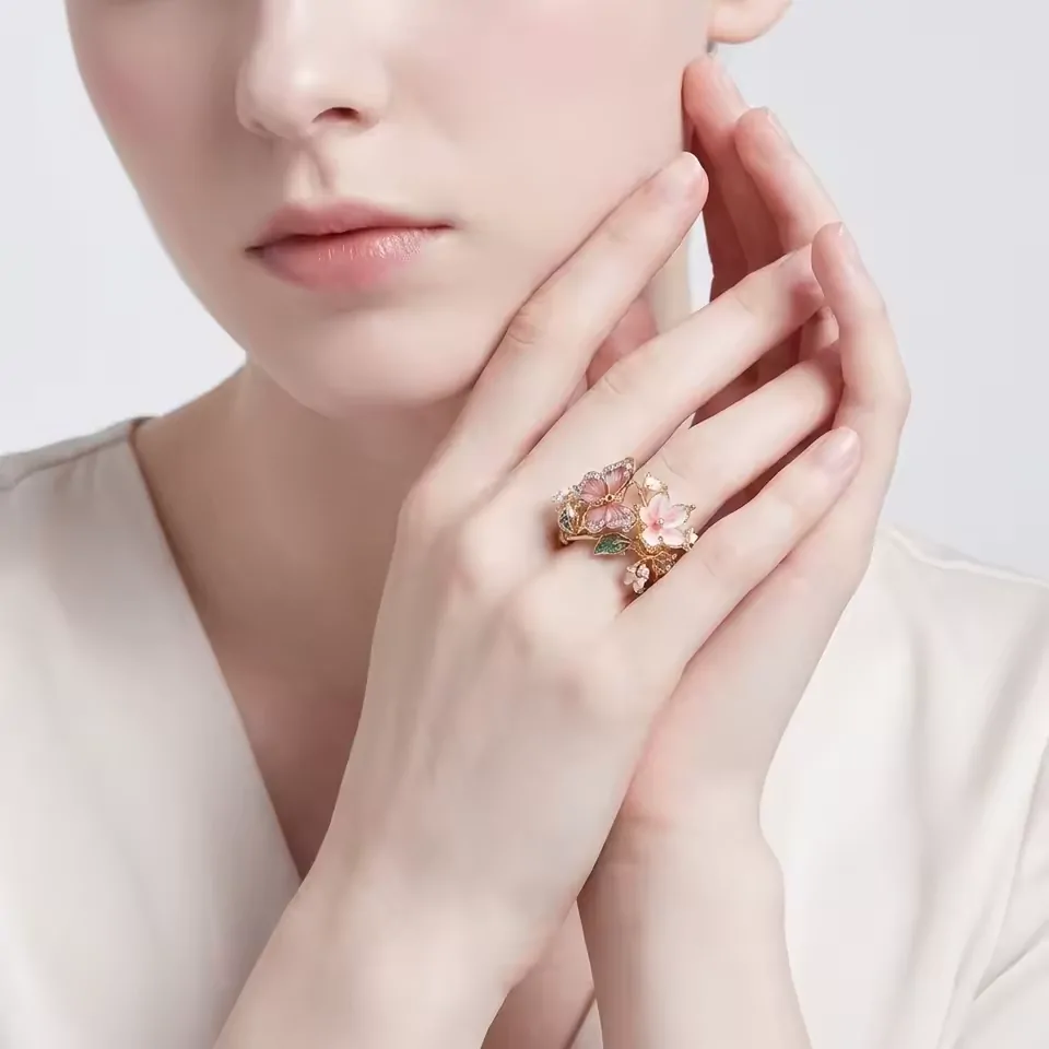 Bague papillon fleurie portée au doigt