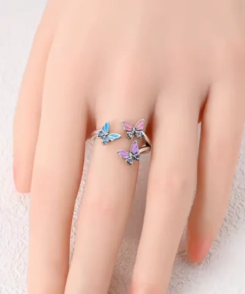 Bague trois papillons colorés portée au majeur