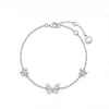 Bracelet papillon phosphorescent argenté, papillon bleu pâle entre deux fleurettes serties
