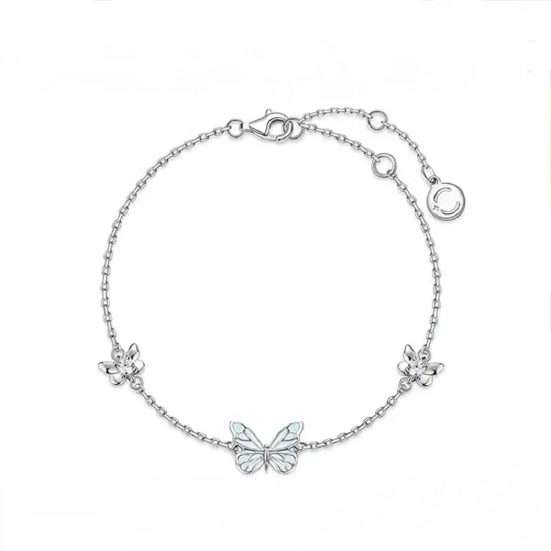 Bracelet papillon phosphorescent argenté, papillon bleu pâle entre deux fleurettes serties