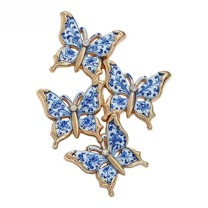 Broche papillon bleu et blanc, quatre papillons en émail façon porcelaine et contour doré