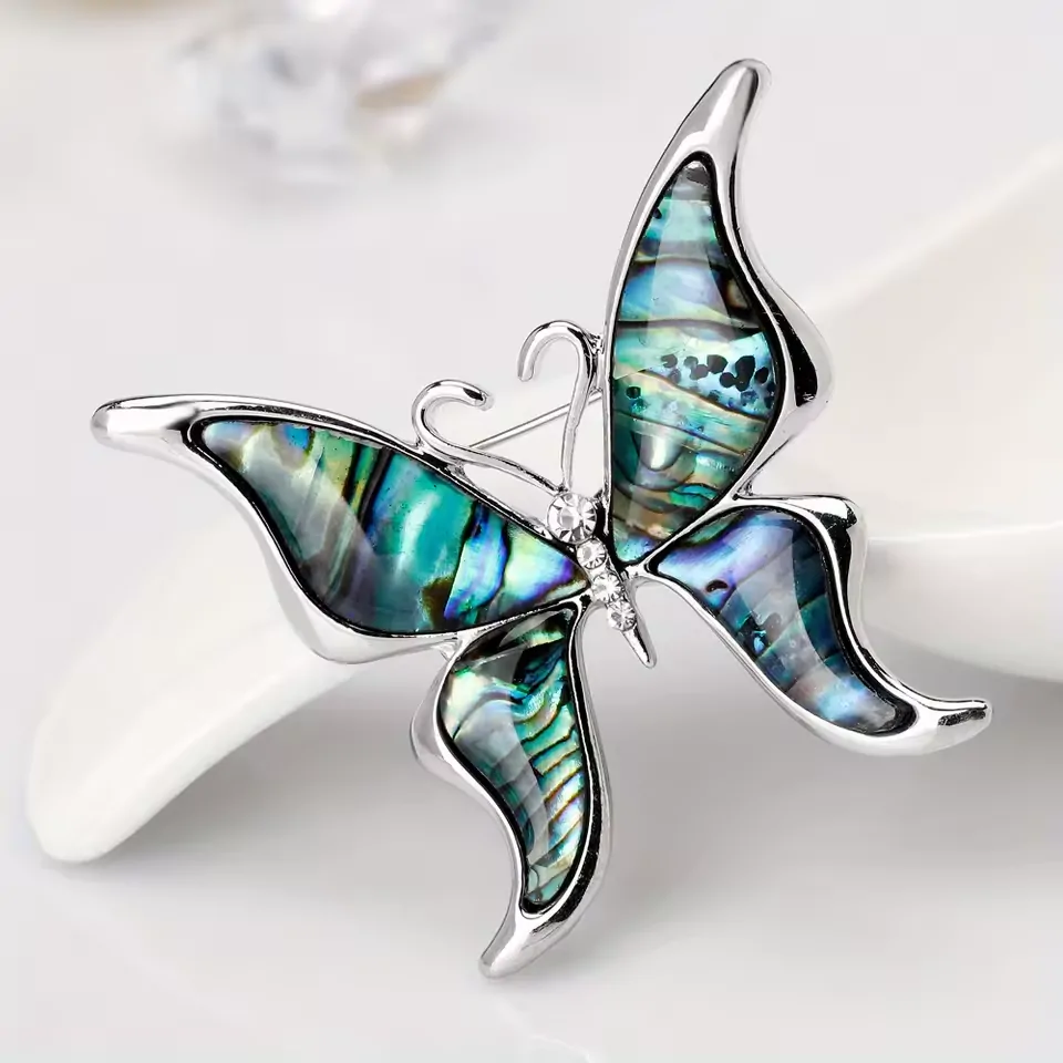 Broche papillon en coquillage, reflets bleus et verts des ailes