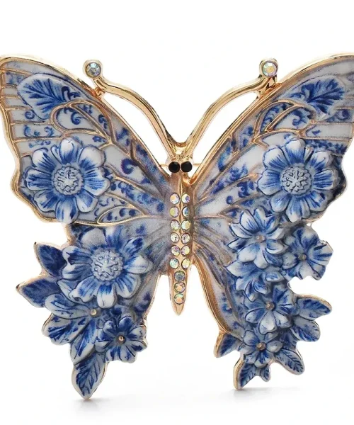 Broche papillon en émail bleu, ailes peintes façon vitrail et fleurs en relief