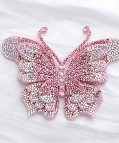 Broche papillon en relief rose, ailes superposées couvertes de strass