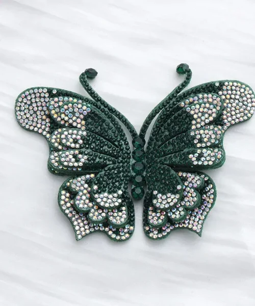 Broche papillon en relief vert, ailes superposées couvertes de strass