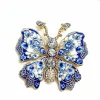 Broche papillon mosaïque bleu et blanc, émail irisé et gros cristaux sur monture dorée