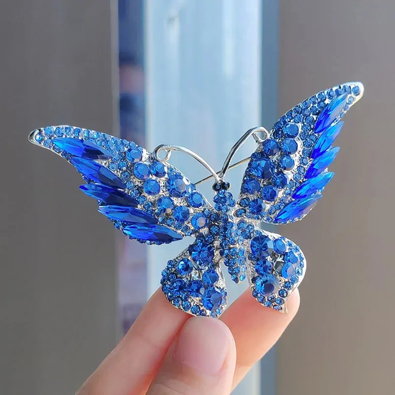 Broche papillon pour écharpe bleu, ailes pavées de strass et cristaux navette