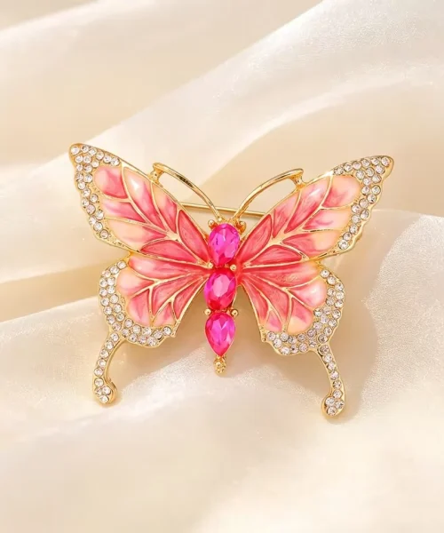 Broche papillon rose en émail, corps en zircons fuchsia et ailes bordées de zircons