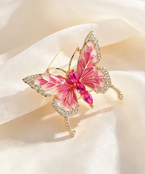 Broche papillon rose, ailes à longues queues et contour pavé de zircons blancs