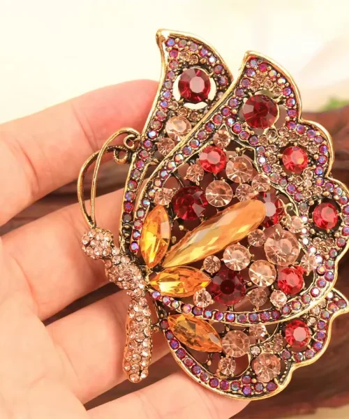 Broche papillon rouge tenue en main, taille 6,6 x 8,3 cm