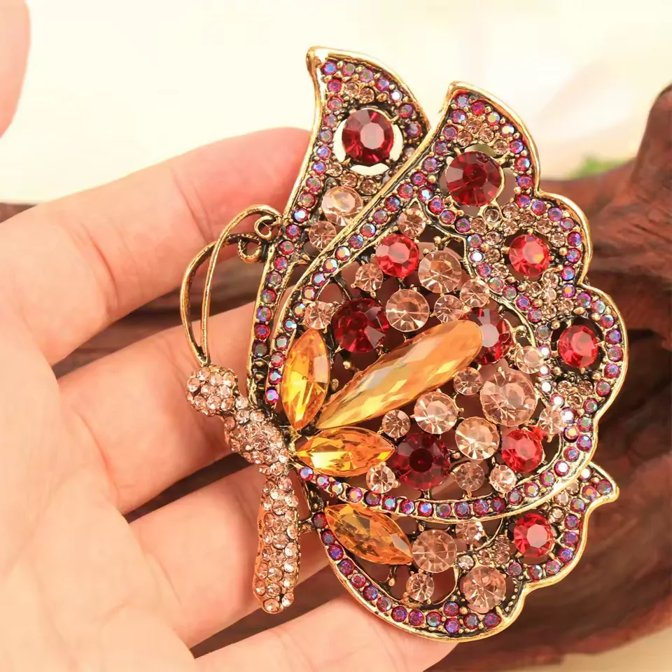 Broche papillon rouge tenue en main, taille 6,6 x 8,3 cm