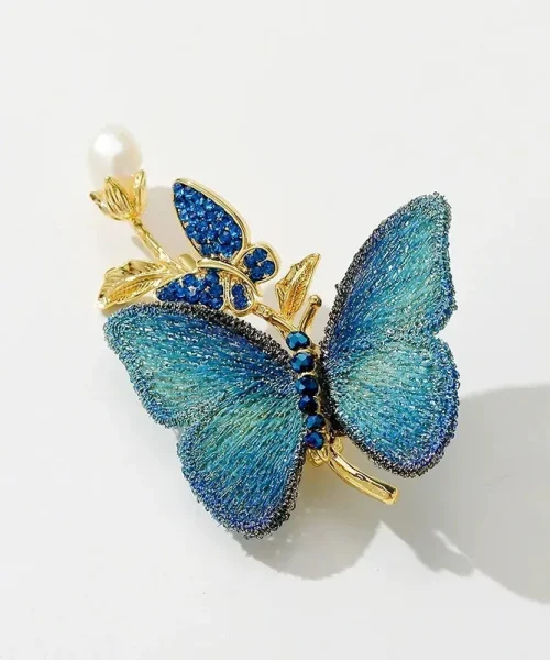 Broche Papillon sur Branche bleu, sur branche dorée avec perle et papillon en strass