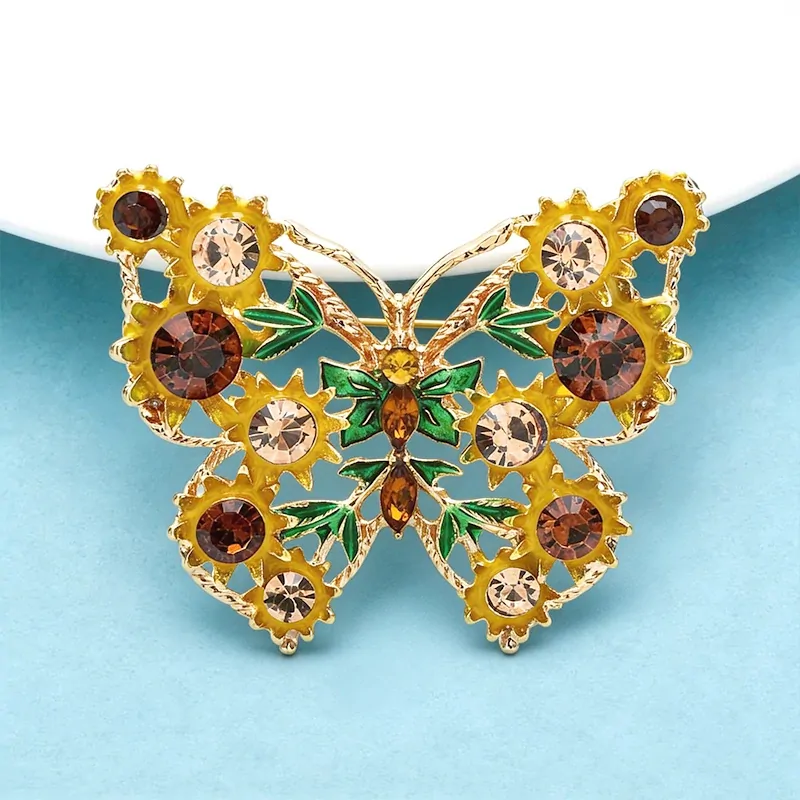 Broche papillon tournesol, détail des feuilles vertes et des pierres navette ambrées