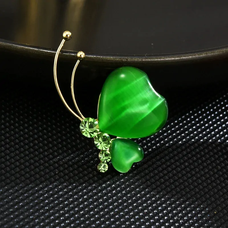 Broche papillon verte, reflet œil-de-chat sur les ailes en cœur