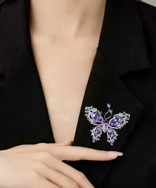 Broche papillon violette portée au revers d'une veste noire