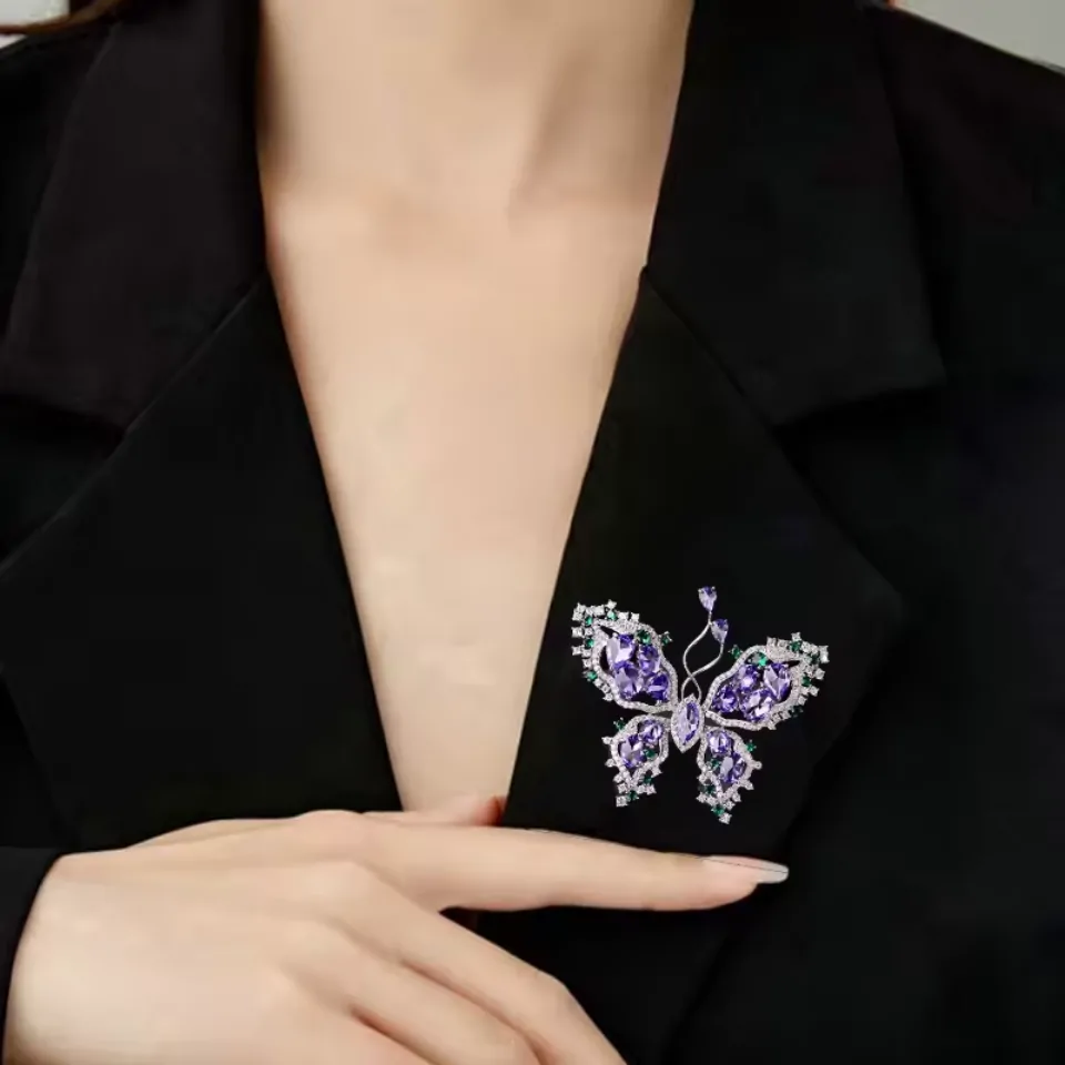 Broche papillon violette portée au revers d'une veste noire