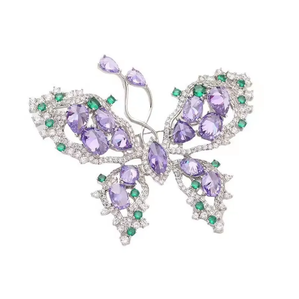 Broche papillon violette ornée de pierres taillées et strass sur monture argentée