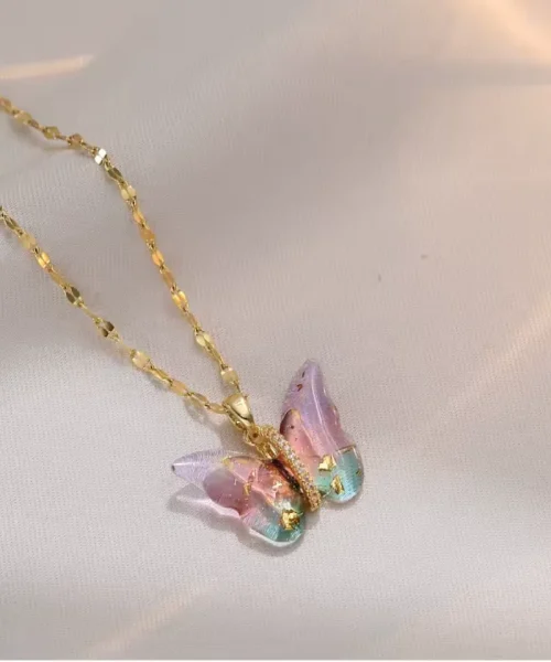 Collier papillon aquarelle rose et bleu sur chaîne dorée, ailes semées d'éclats dorés