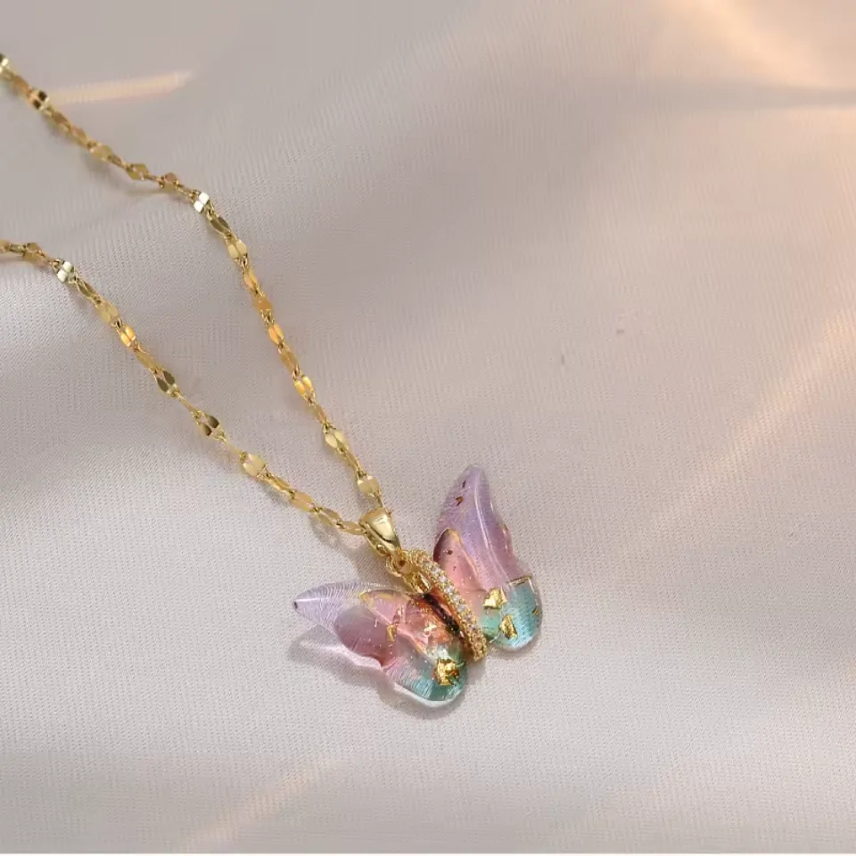 Collier papillon aquarelle rose et bleu sur chaîne dorée, ailes semées d'éclats dorés