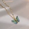 Collier papillon aquarelle vert sur chaîne dorée, ailes translucides en dégradé et éclats dorés