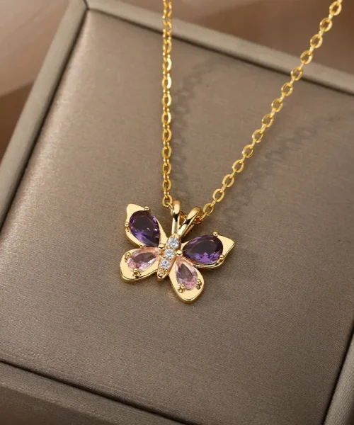 Collier papillon cristal doré posé sur un écrin