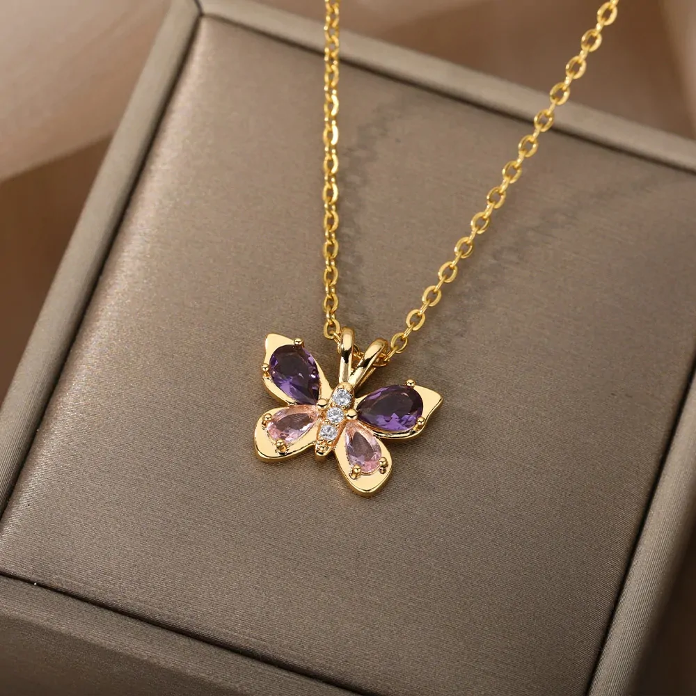 Collier papillon cristal doré posé sur un écrin