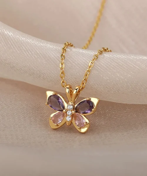 Détail du papillon doré à quatre ailes en cristal violet et rose