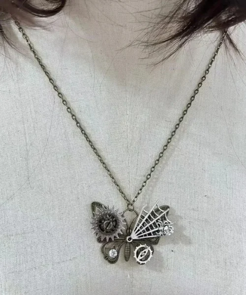 Collier papillon steampunk porté, pendentif à rouages et ailes dépareillées