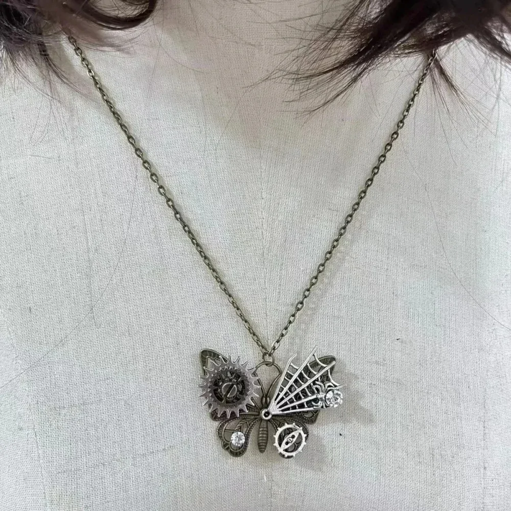 Collier papillon steampunk porté, pendentif à rouages et ailes dépareillées