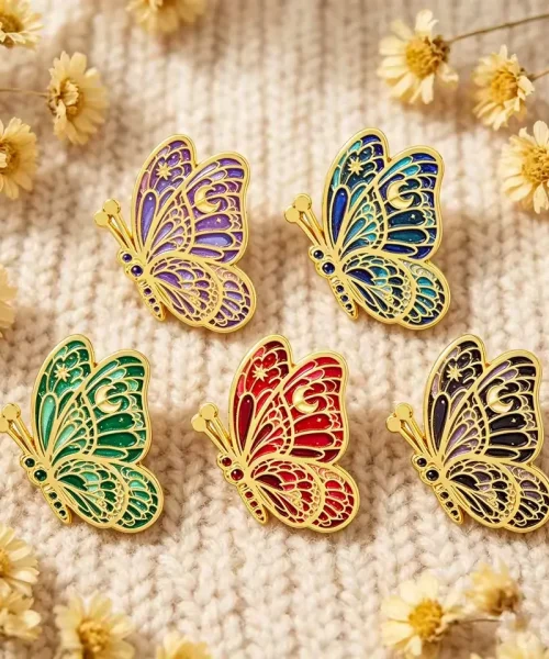 Lot de 5 pin's papillon lune posés sur un pull en maille crème