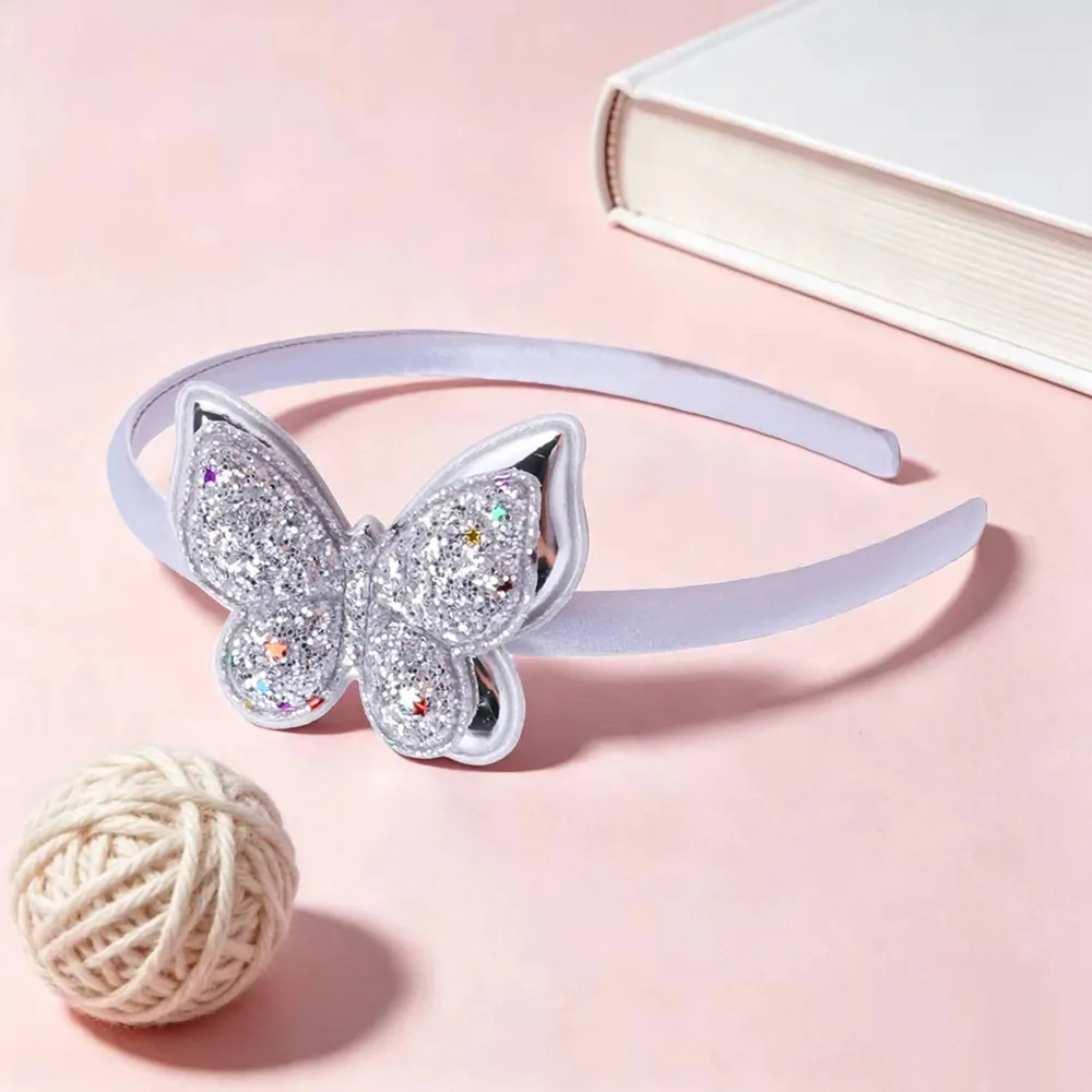 Serre-tête papillon pailleté argenté, arceau satiné et papillon à paillettes semé d'étoiles