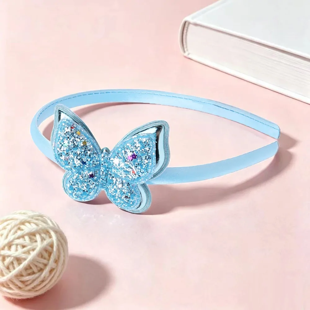 Serre-tête papillon pailleté bleu ciel, arceau satiné et papillon à paillettes semé d'étoiles