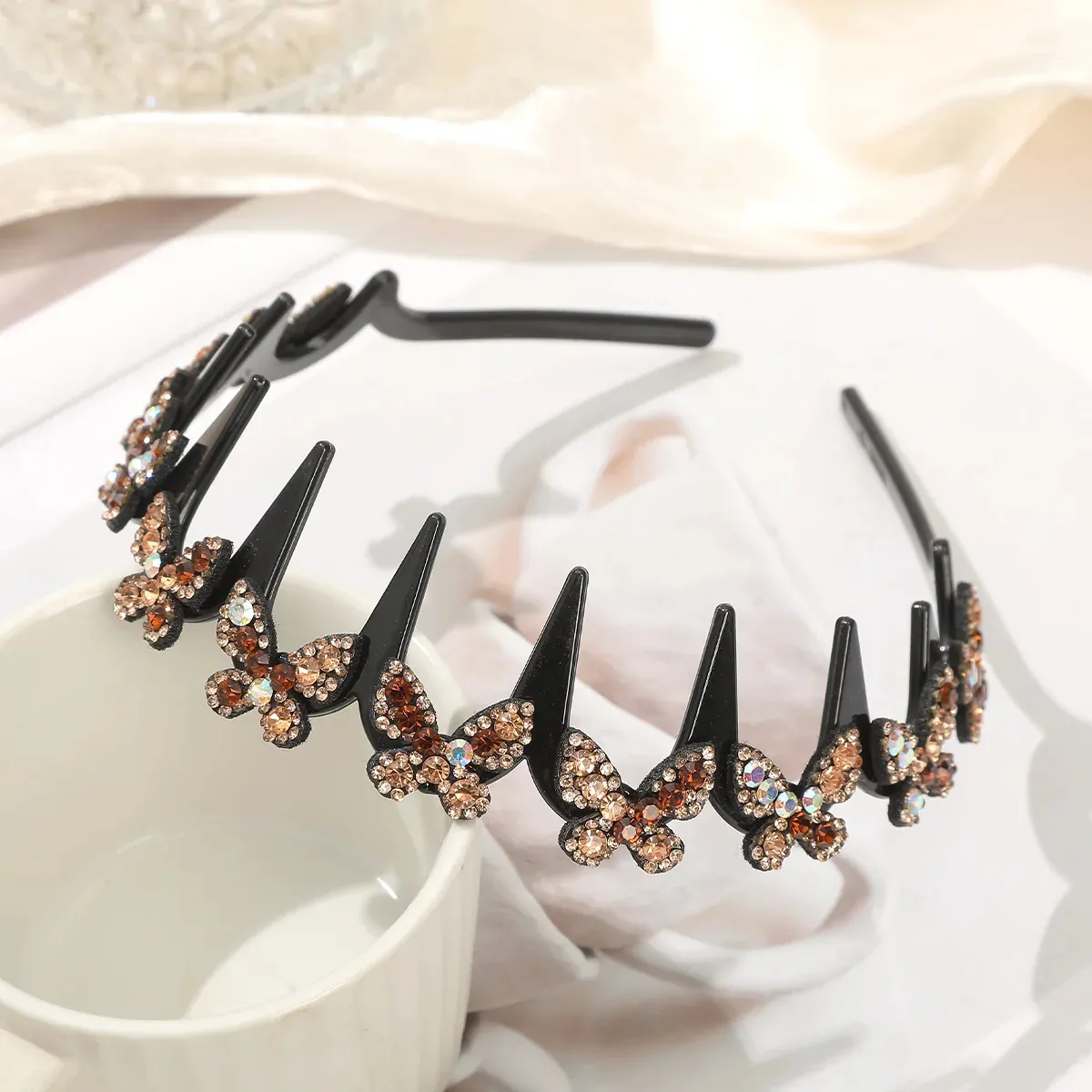 Serre-tête papillon strass champagne, arceau ondulé à dents noir couronné de papillons pavés